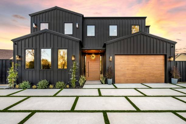 Home exterior with dark siding and wood-tone garage door by a house painter in Corvallis, OR.