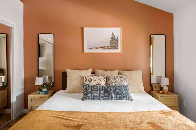 Bedroom with warm terracotta paint and crisp white trim by a house painter in Tangent, OR.